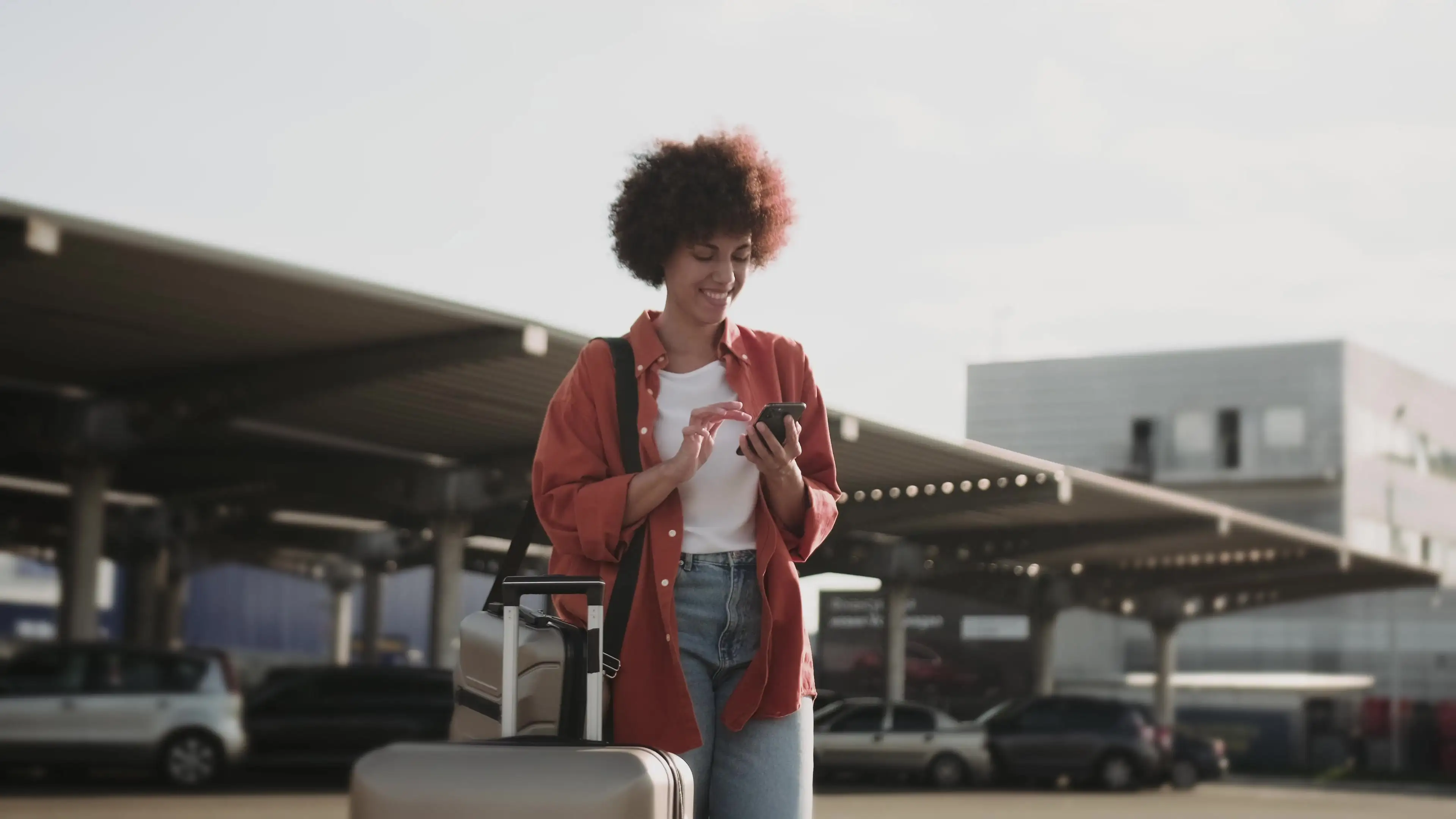 Dame am Telefon vor dem Flughafen
